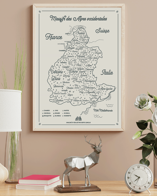 Affiche carte des Alpes occidentales Sortie Longue encadrée dans un intérieur ; carte massifs, lacs, villes repères et empreintes d’animaux, déco murale cartographie montagne, idée cadeau à offrir.
