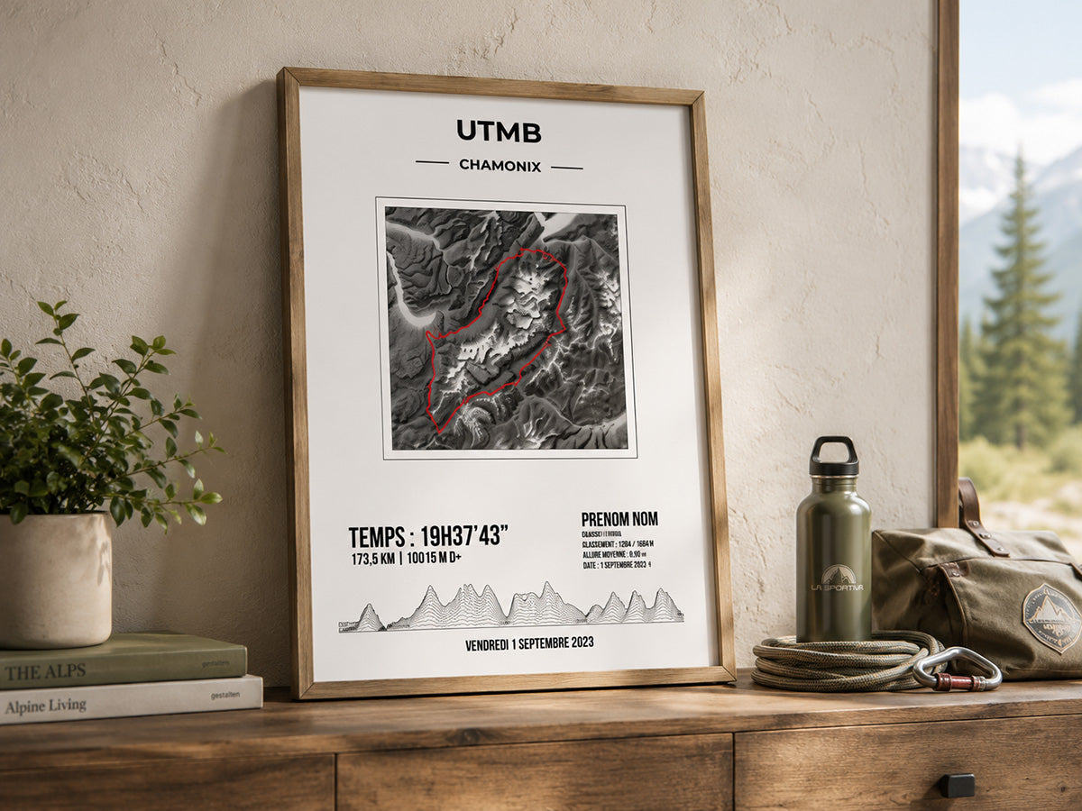 Affiche trail personnalisée UTMB encadrée près d’une fenêtre, avec carte en relief, trace rouge du parcours et décor outdoor calme.