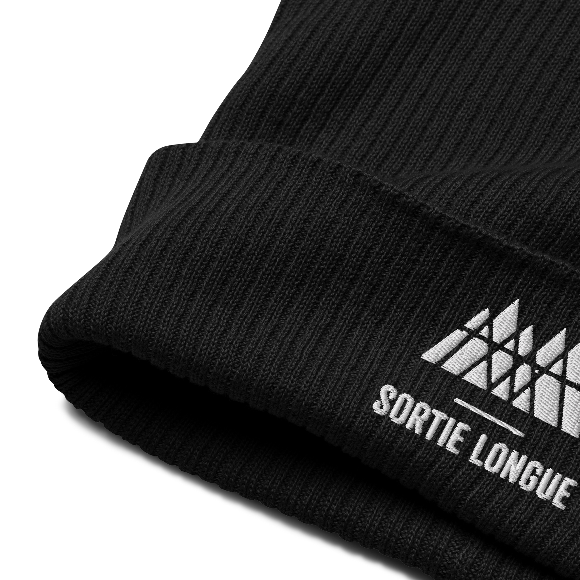 Détail de la maille et du revers d’un bonnet tricoté Sortie Longue en coton biologique, broderie du logo visible.