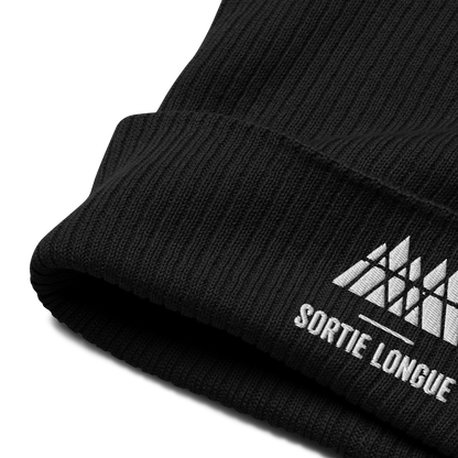 Détail de la maille et du revers d’un bonnet tricoté Sortie Longue en coton biologique, broderie du logo visible.