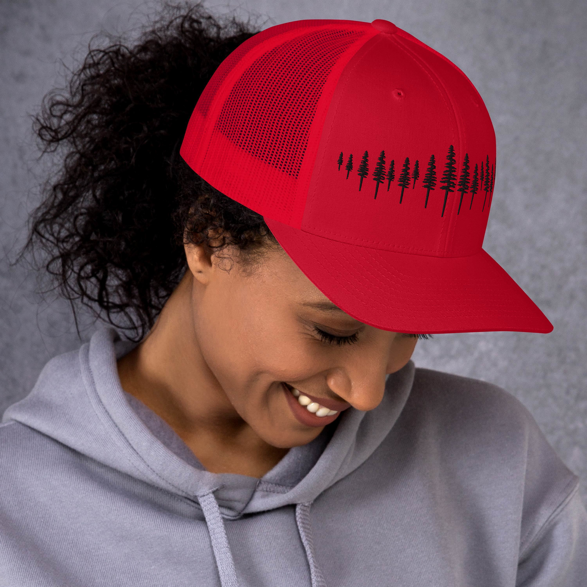 Casquette trucker Sortie Longue portée, coloris rouge, broderie forêt de sapins contrastée évoquant la progression en forêt.