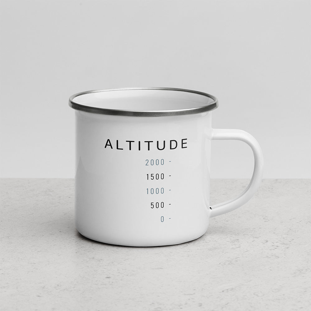 Face avant du mug Altitude avec design graphique minimaliste, chiffres de hauteur et typographie espacée sur mug émaillé blanc.