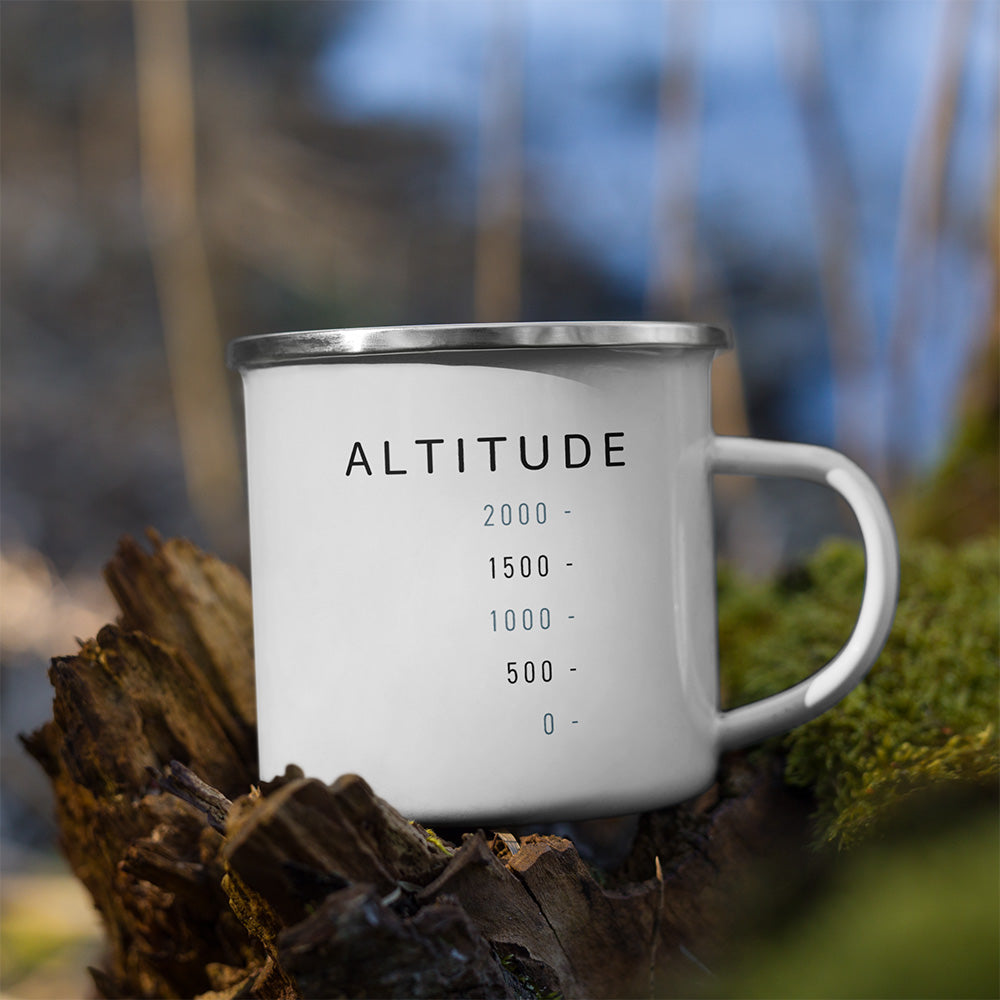 Mug Altitude Sortie Longue posé sur une roche en extérieur, avec échelle graphique sobre et graduations de hauteur.