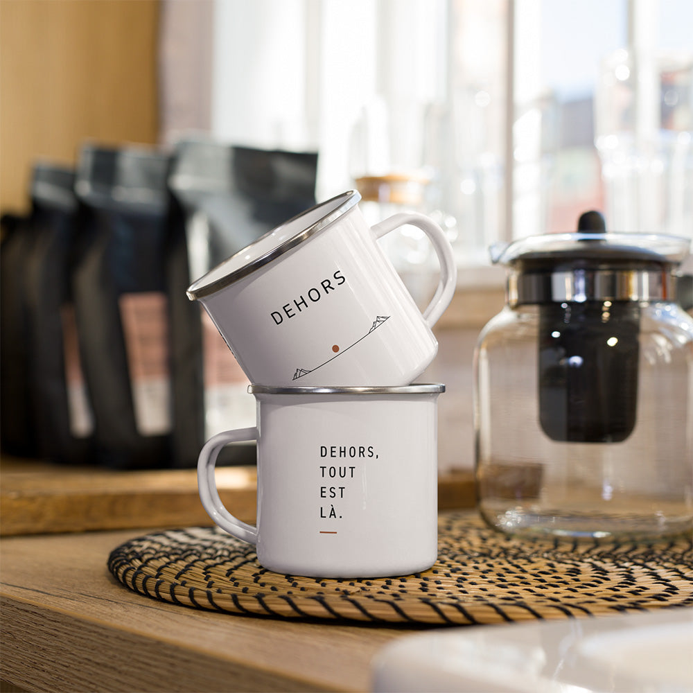 Deux mugs émaillés blancs Sortie Longue avec design Dehors, face avant minimaliste et phrase Dehors, tout est là.