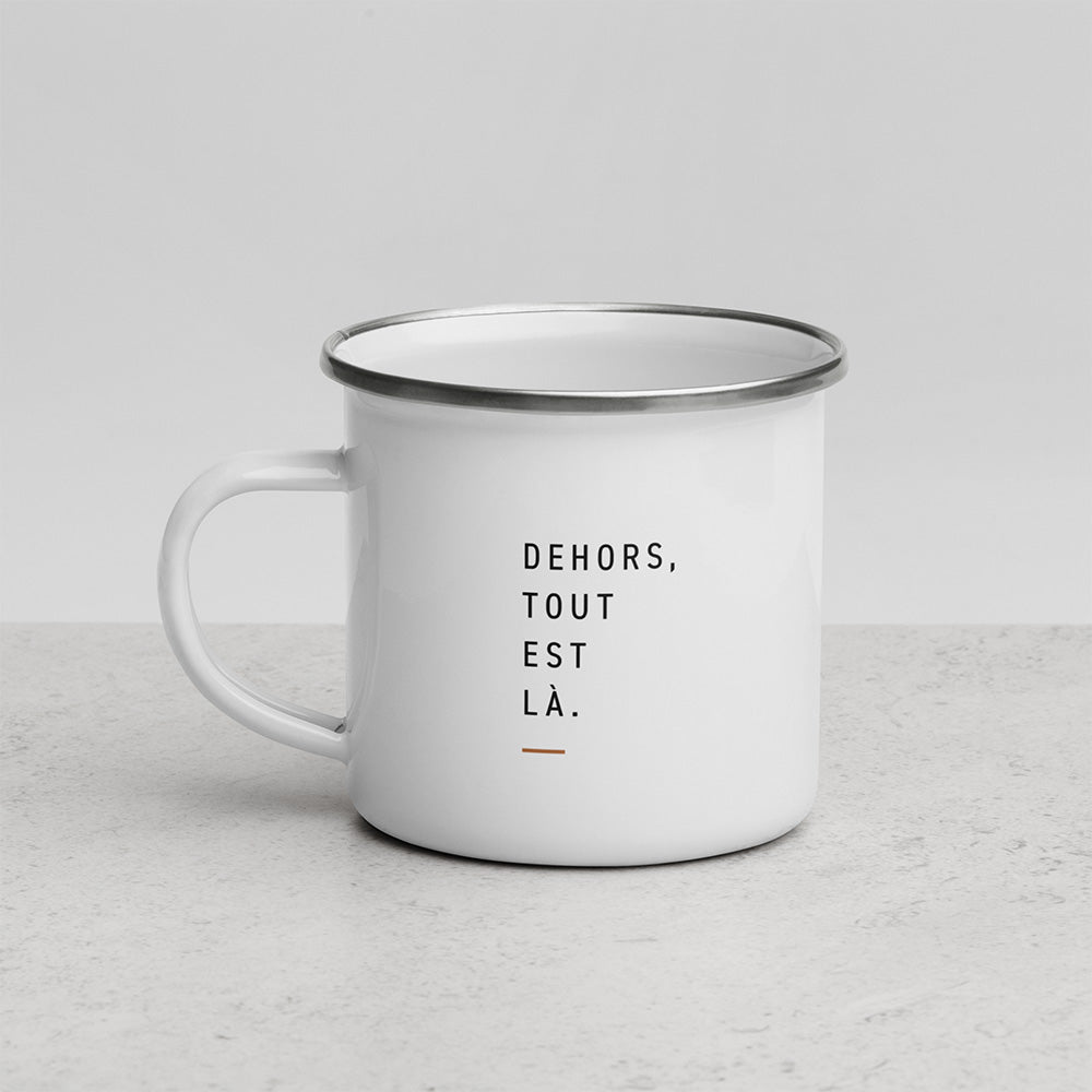 Verso du mug Dehors avec la phrase Dehors, tout est là sur mug émaillé blanc, présenté sur fond clair minimaliste.