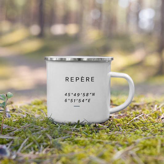 Mug émaillé Repère posé dehors sur la mousse, avec design minimaliste inspiré des repères de terrain et de l’orientation.