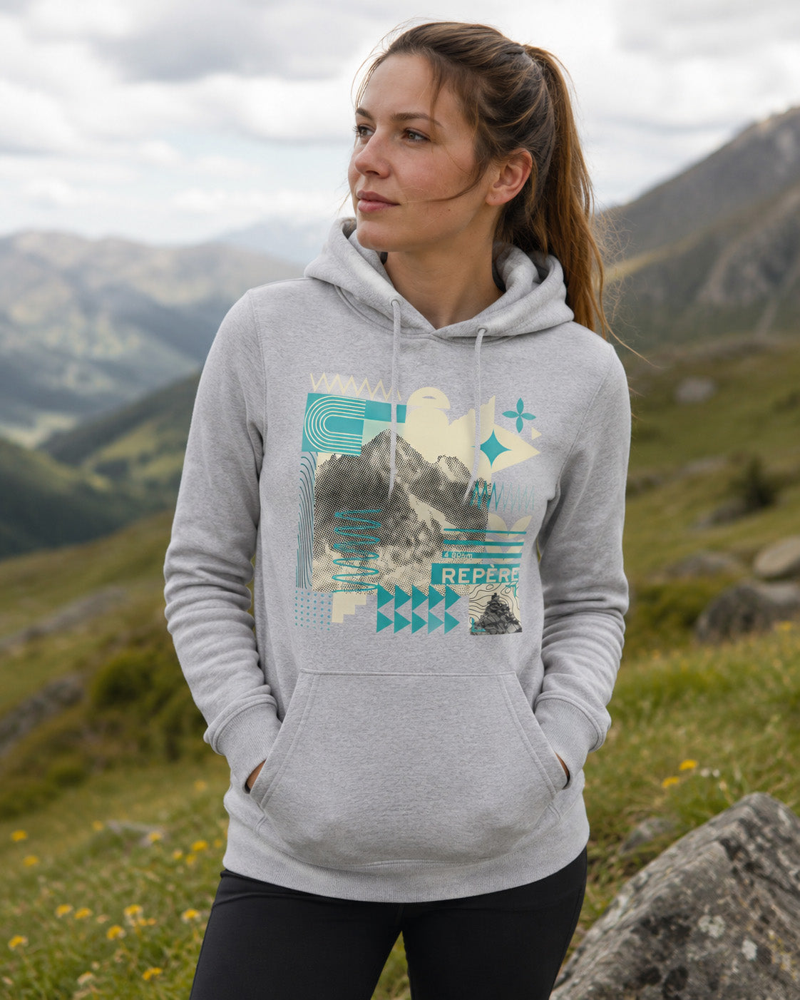 Sweat à capuche unisexe Repère Sortie Longue blanc porté par une femme sur un sentier de randonnée en montagne