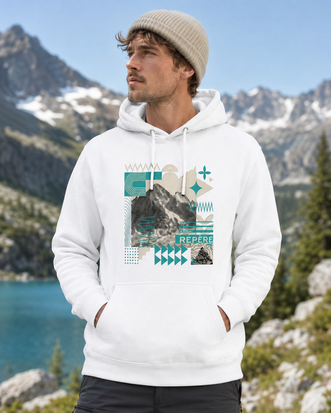 Sweat à capuche unisexe Repère Sortie Longue blanc porté par un homme devant un lac de montagne