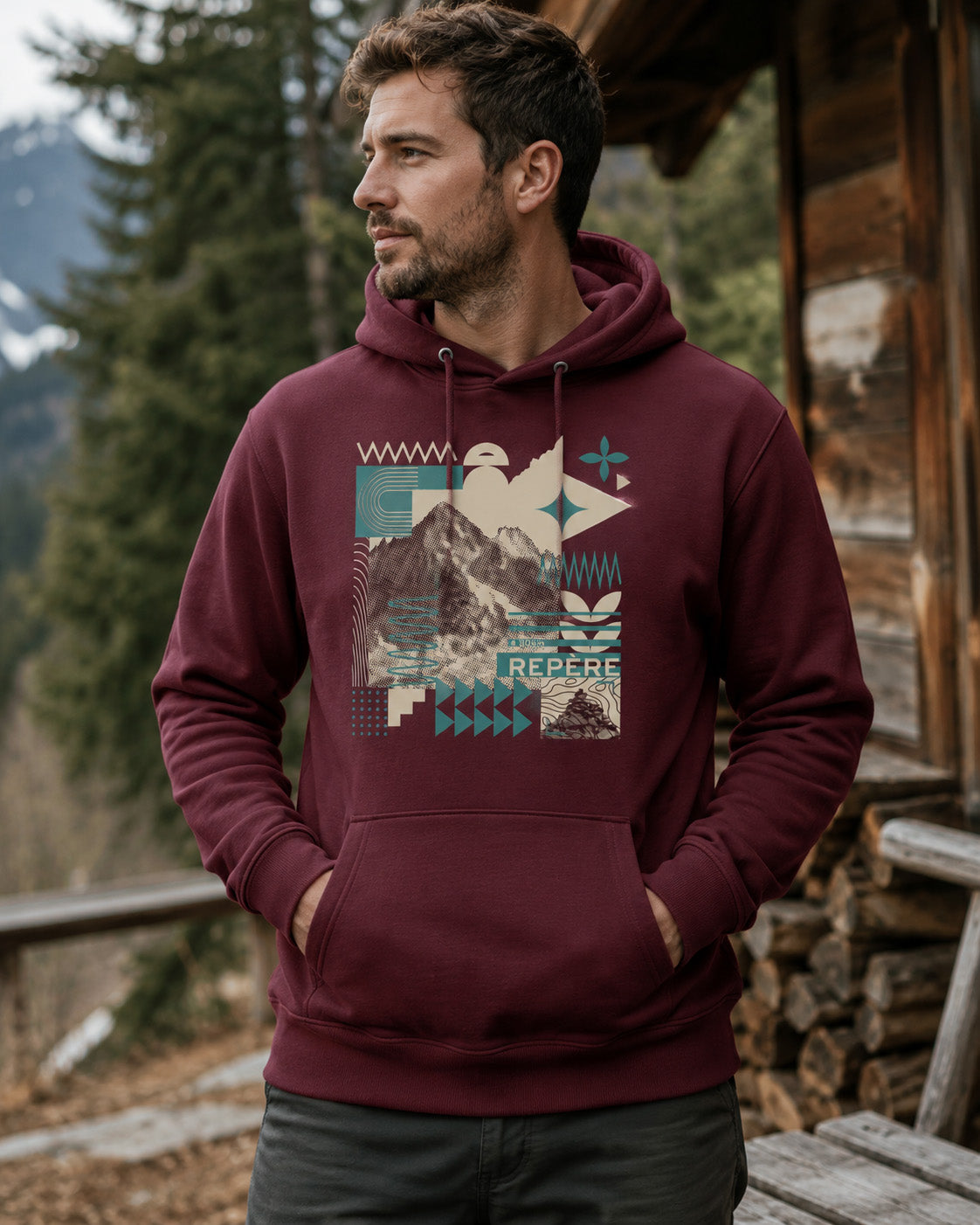 Sweat à capuche unisexe Repère Sortie Longue bordeaux porté par un homme devant un chalet en montagne