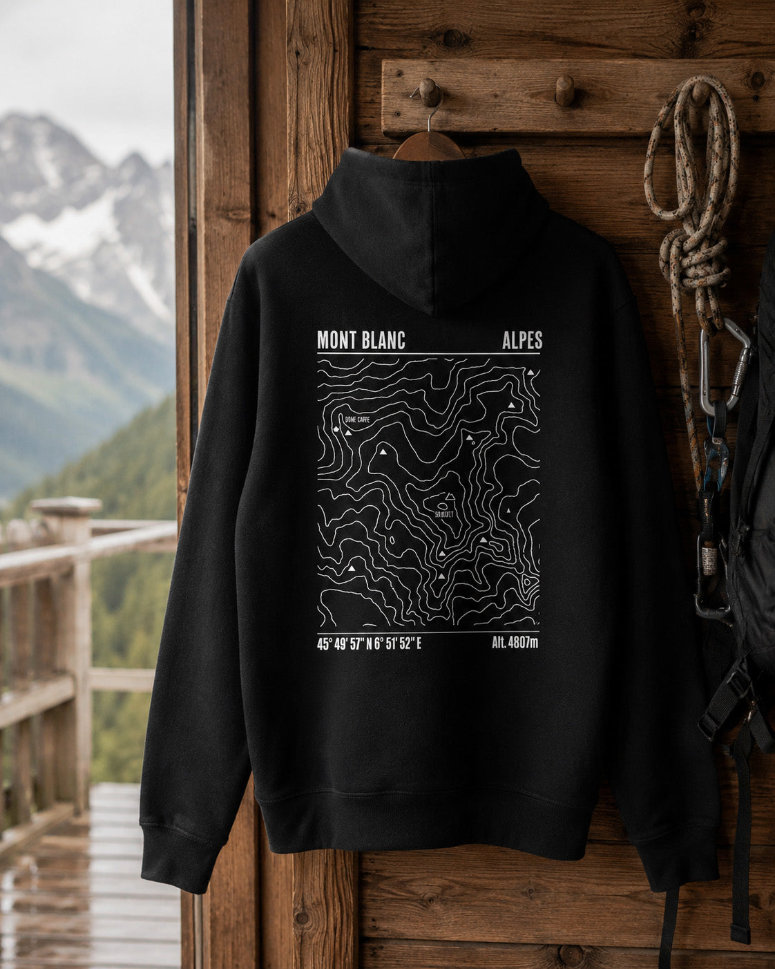 Sweat à capuche noir Sortie Longue avec carte du Mont Blanc au dos, suspendu en décor montagne