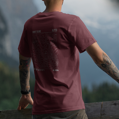 T-shirt unisexe Sortie Longue bordeaux porté, vue de dos en extérieur, silhouette en marche avec montagne en arrière-plan, motif carte topo Mont Blanc imprimé; tenue sentier et randonnée.