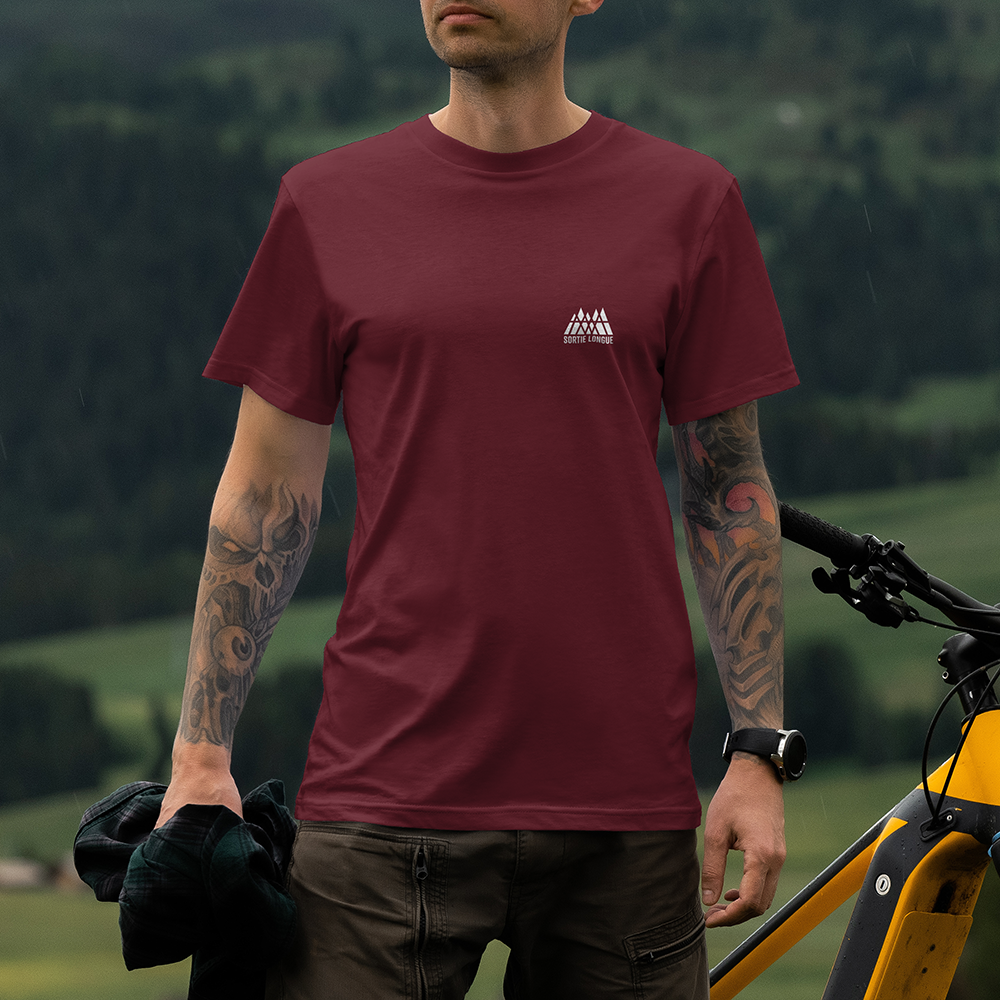 T-shirt unisexe Sortie Longue bordeaux porté, vue de face près d’un vélo, petit logo poitrine; tenue outdoor pour approche, déplacement et après-course, design Mont Blanc imprimé au dos.