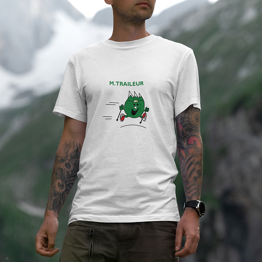 Modèle portant le t-shirt Sortie Longue blanc en extérieur, vue de face, design « Mr Traileur » avec personnage minimal, lampe frontale, bâtons et baskets; t-shirt unisexe pour trail et quotidien.