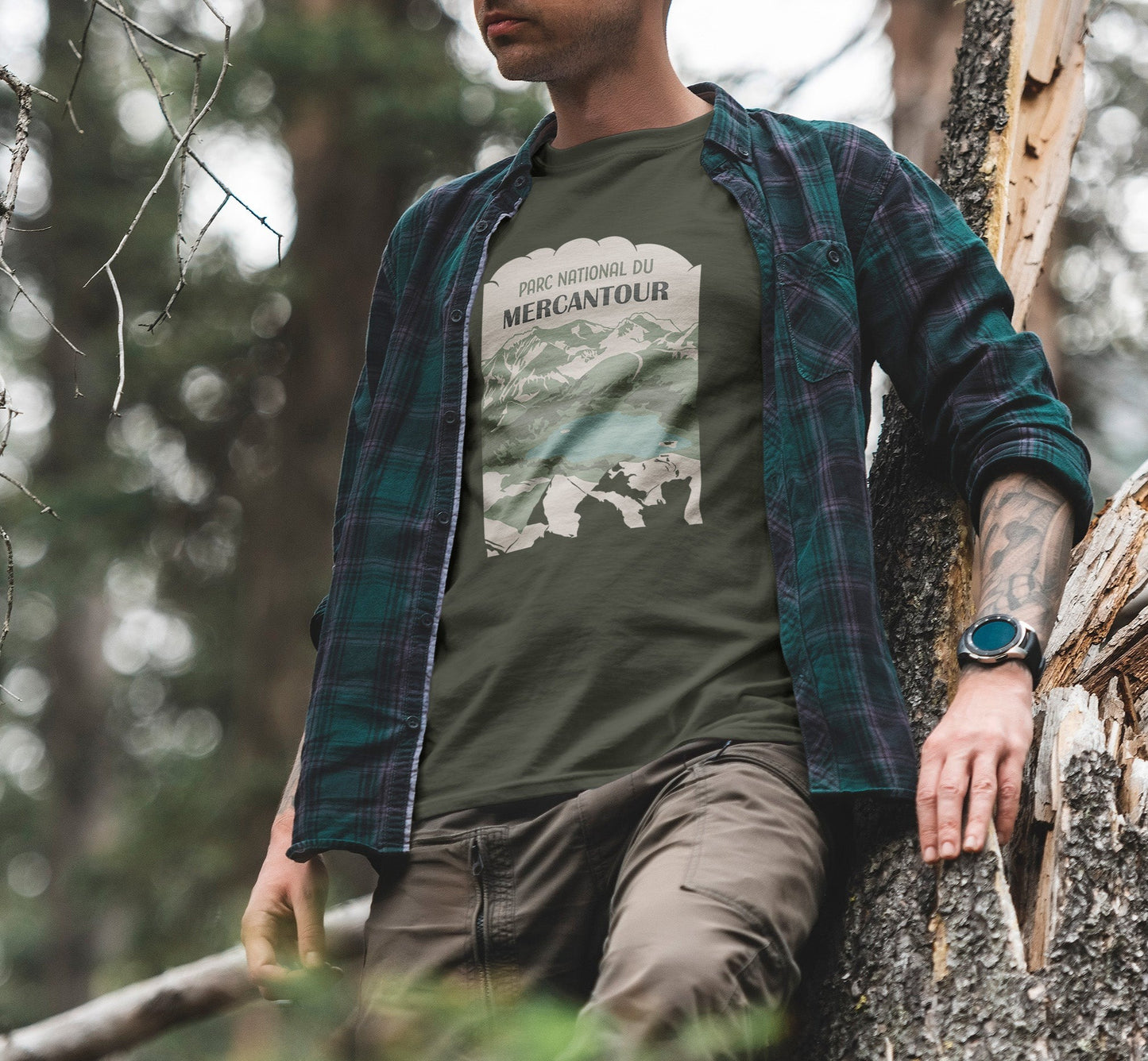 Modèle portant le t-shirt Sortie Longue bleu marine en extérieur, vue de face, visuel Parc national du Mercantour avec Lac d’Allos et combes du Pelat depuis le col de l’Encombrette; tenue pour marche, randonnée et sentier.