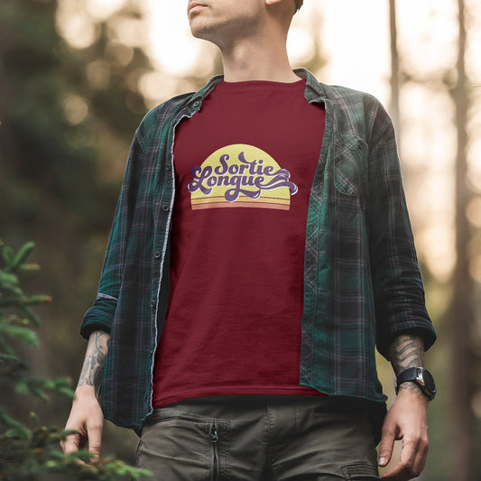 T-shirt unisexe Sortie Longue bordeaux porté en extérieur, vue de face, lettrage rétro « Sortie Longue » sur dégradé soleil, tenue sobre pour marche, vélo et sorties dehors.
